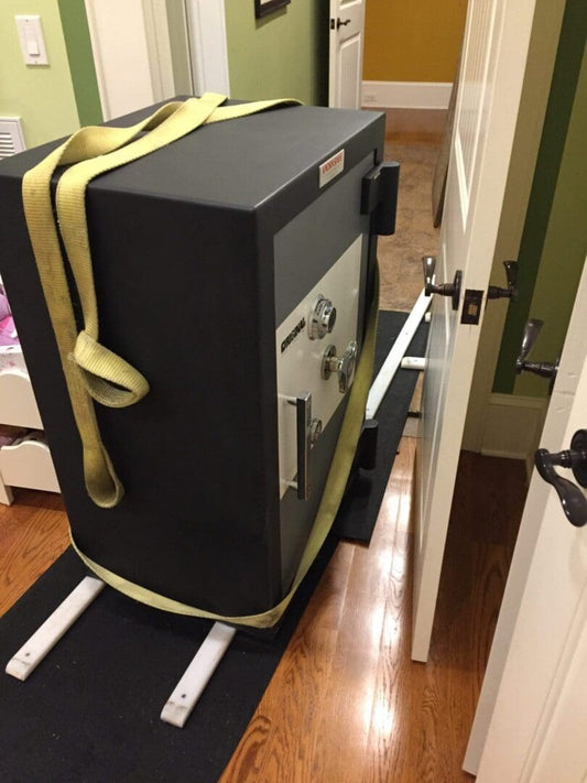 Large safe being moved through doorway.